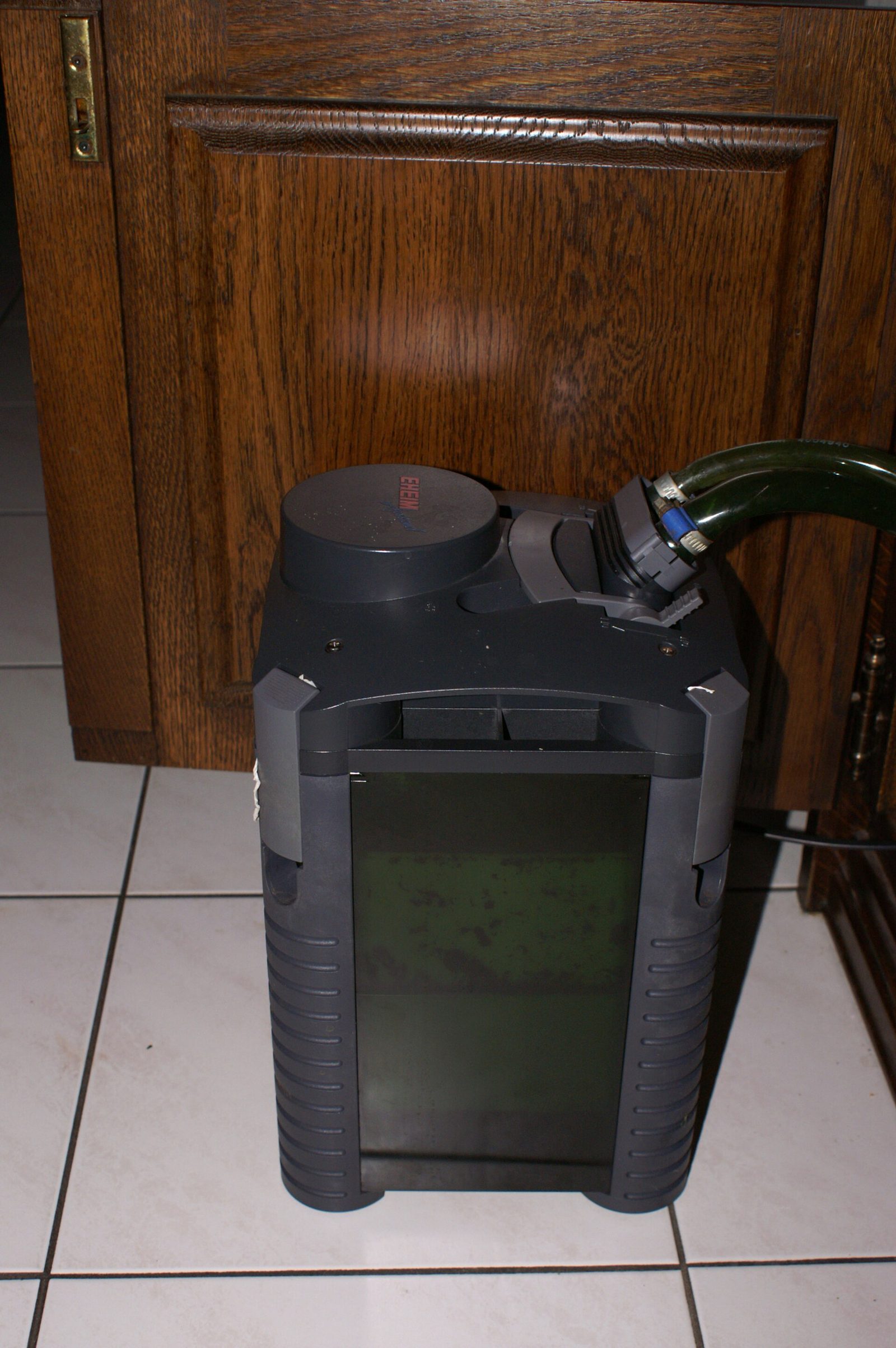 External canister filter beside an aquarium cabinet